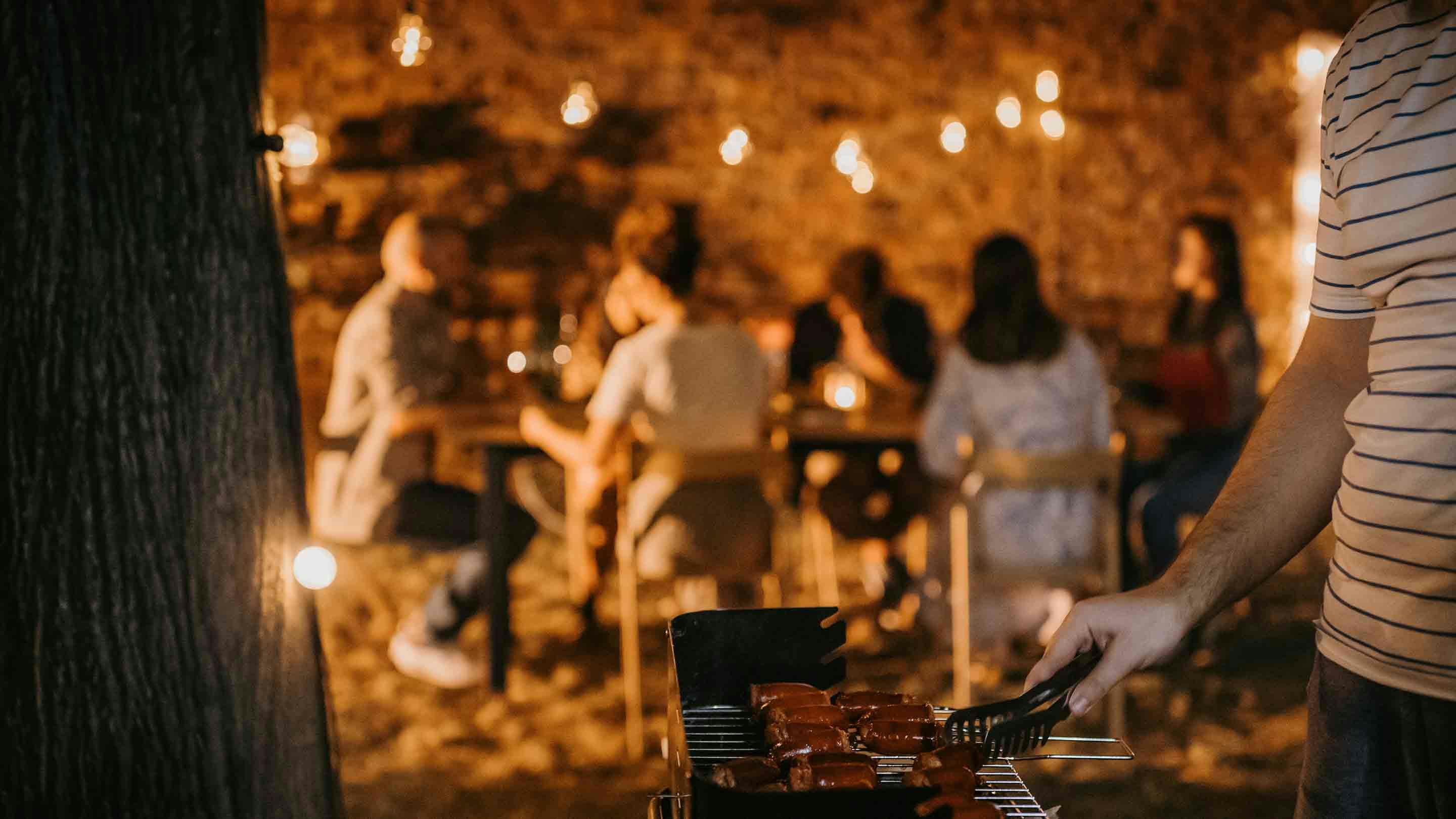 Barátok élvezik a tündérfényben úszó BBQ estet